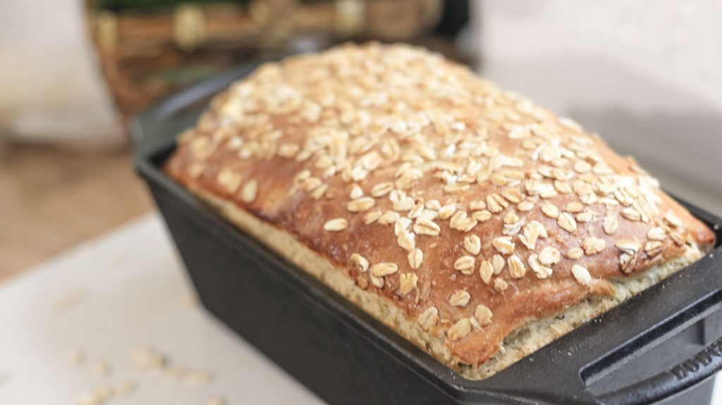 sourdough honey oat bread in a cast iron loaf pan
