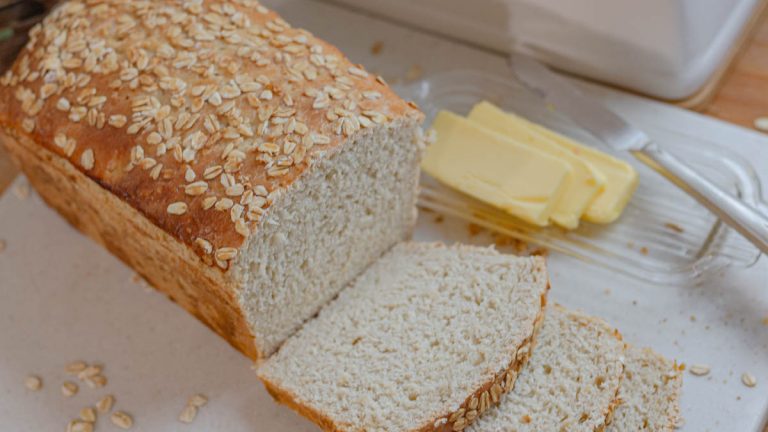 Sliced of Sourdough Honey oat Bread loaf with butter