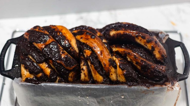 sougdough babka with chocolate top inside a loaf pan