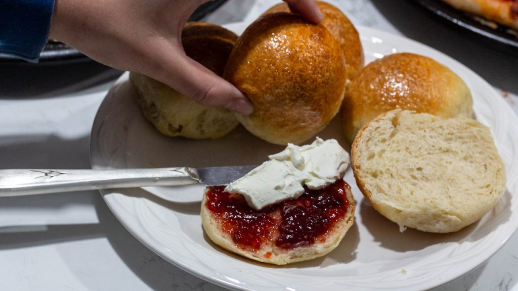 hand holding sourdough brioche rolls on plate