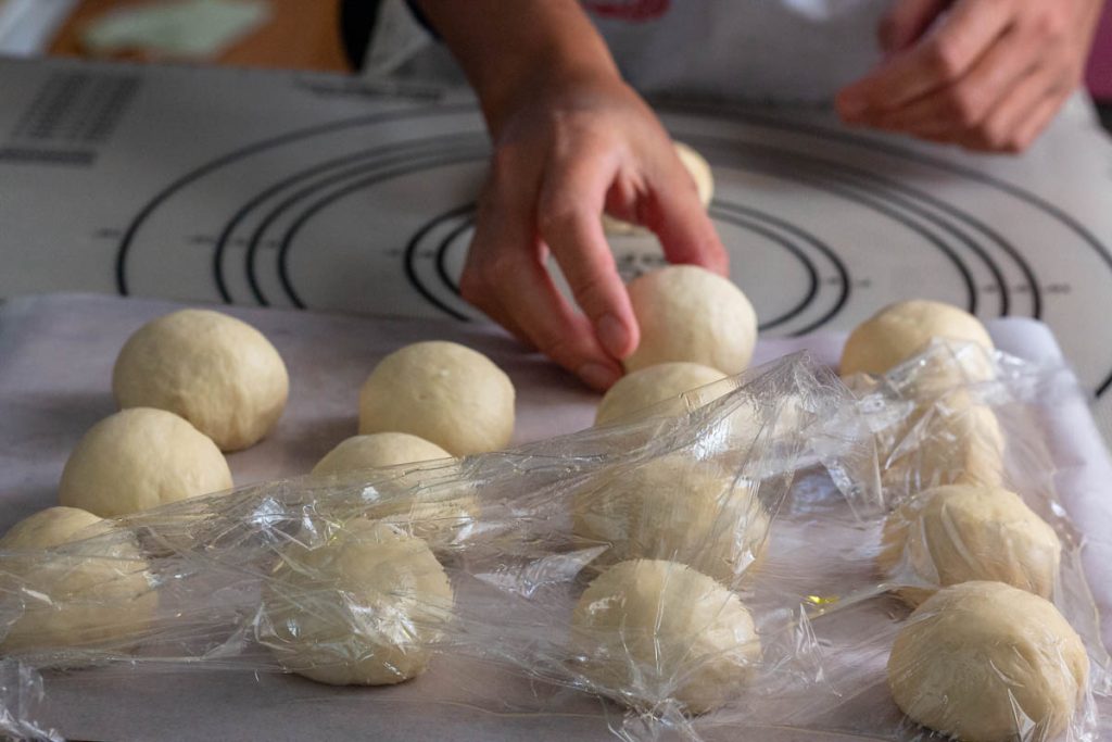 woman holding rounded sourdough balls