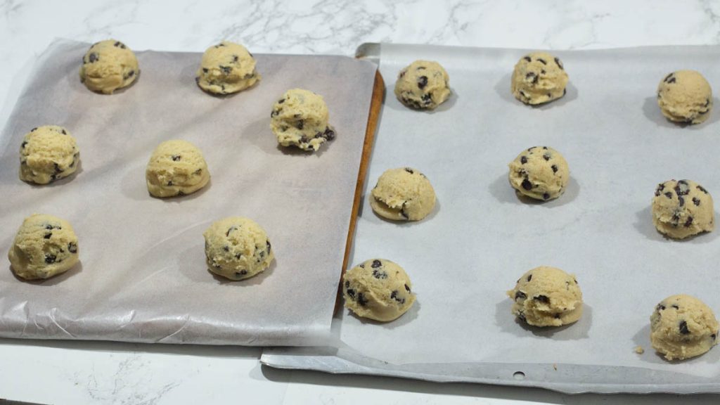 scooped out sourdough cookie dough on baking sheet